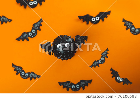Model of Covid virus in the shape of a bat with flying bats in the background. Scariest hero in Halloween 2020. Halloween during Corona virus global pandemic concept. Selective focus. Model of Covid virus in the shape of a bat with flying bats in the background. Scariest hero in Halloween 2020. Halloween during Corona virus global pandemic concept. Selective focus. 70106598