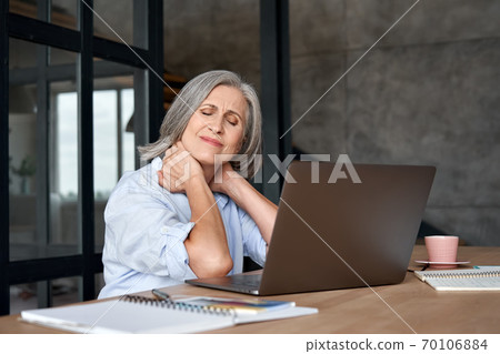 Tired stressed older mature business woman suffering from neck pain. 70106884