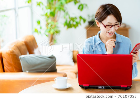 在客廳裡使用電腦的中年女人 在客廳裡使用電腦的中年女人 70107055