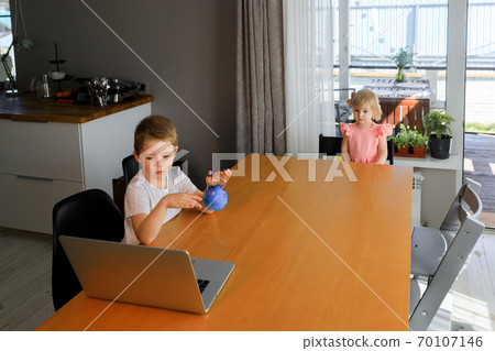 A little boy and a girl watch cartoons on a laptop A little boy and a girl watch cartoons on a laptop 70107146