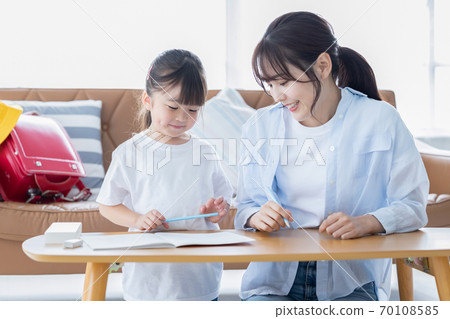 Family image Girl doing homework with mom 70108585