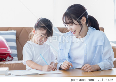 Family image Girl doing homework with mom 70108586