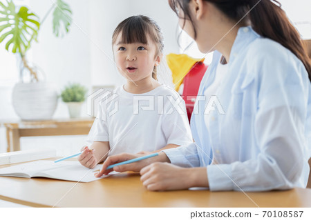 Family image Girl doing homework with mom 70108587