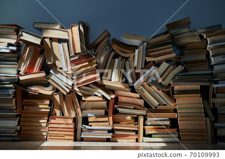 Wall of books piled up in the attic 70109993