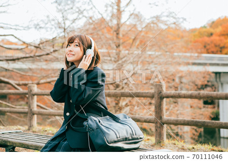 High school students listening to music in a winter park 70111046
