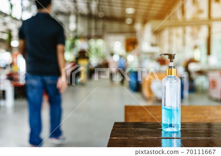 Blue alcohol gel bottle for hand cleaning to prevent the spreading of the Coronavirus (Covid-19) to service for customers placed on table at cafeteria. Healthcare concept. New normal lifestyle 70111667