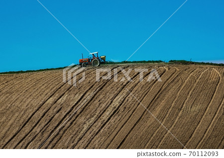 Tractor doing farm work on the hill (Hokkaido Biei-cho) Tractor doing farm work on the hill (Hokkaido Biei-cho) 70112093