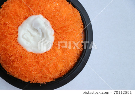 Gold Egg Yolk Thread Cakes in the black round tray on the white floor. Gold Egg Yolk Thread Cakes in the black round tray on the white floor. 70112891