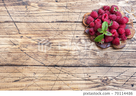 A pile of fresh juicy raspberries on a wooden Board, copy space. 70114486