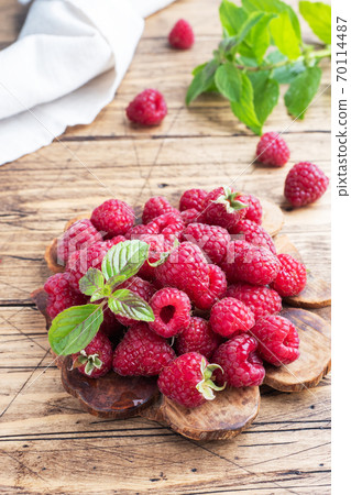 A pile of fresh juicy raspberries on a wooden Board, copy space. 70114487