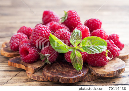 A pile of fresh juicy raspberries on a wooden Board, copy space. 70114488