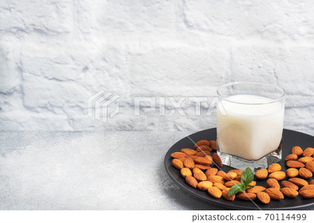 Almond milk in glass glasses on a gray background. Copy space. Almond milk in glass glasses on a gray background. Copy space. 70114499