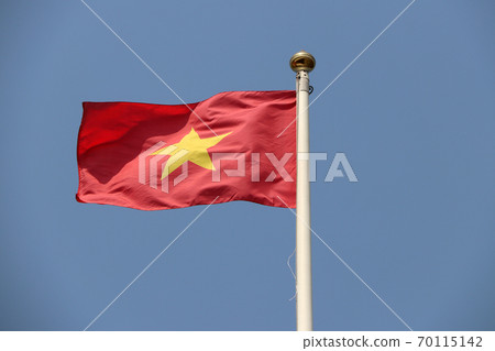 National flag of Vietnam on bright blue sky background. Blown away by wind. National flag of Vietnam on bright blue sky background. Blown away by wind. 70115142