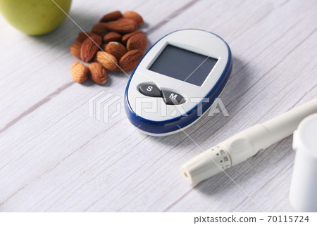 diabetic measurement tools, almond nuts and apple on table diabetic measurement tools, almond nuts and apple on table 70115724