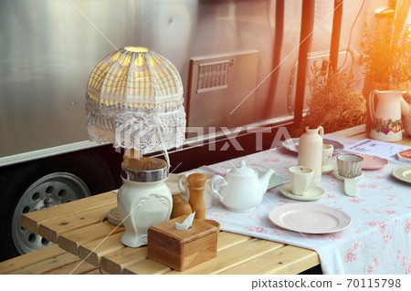 Picnic set on the wooden table beside the van, consist of fabric desk lamp Picnic set on the wooden table beside the van, consist of fabric desk lamp 70115798