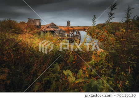 Wooden mill. Cloudy autumn day in a countryside mill village. 70116130