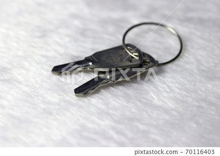 Mini metal two keys put on the white fabric floor. Mini metal two keys put on the white fabric floor. 70116403