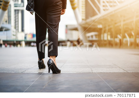 business female legs in high heels shoes walking in city 70117871