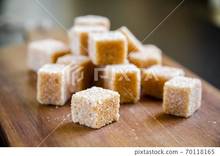 Brown cane sugar cubes on a cutting board 70118165