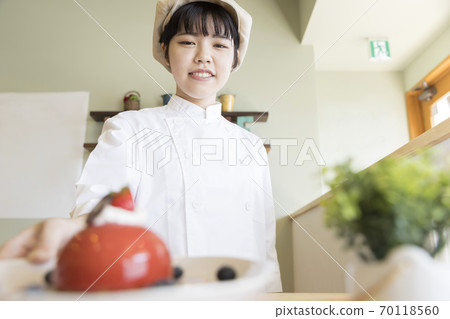 Female cafe staff serving cakes Patissier Female cafe staff serving cakes Patissier 70118560