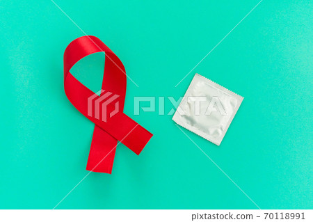Red ribbon with a condom on a blue background 70118991