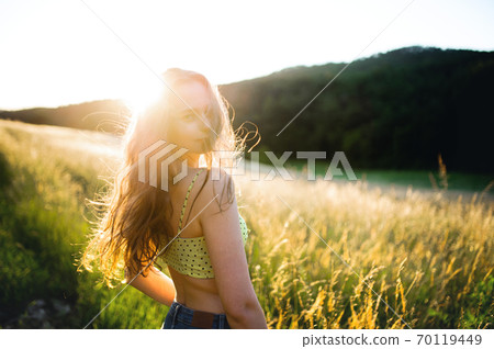 Portrait of young teenager girl outdoors in nature at sunset. Portrait of young teenager girl outdoors in nature at sunset. 70119449