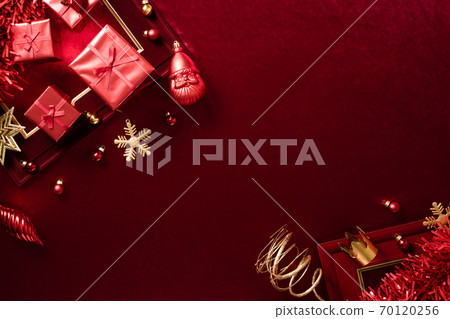 red christmas decoration bauble and ribbon on velvet red felt fabric  top view table backgorund 70120256