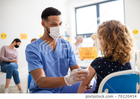 Child with face mask getting vaccinated, coronavirus, covid-19 and vaccination concept. 70120454