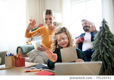 Family with small daughter indoors at home at Christmas, having video call. Family with small daughter indoors at home at Christmas, having video call. 70120541