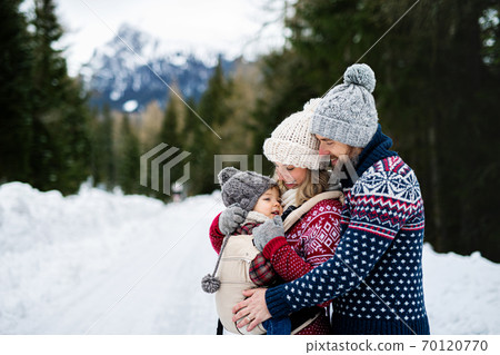 Father and mother with small child in winter nature, standing in the snow. Father and mother with small child in winter nature, standing in the snow. 70120770