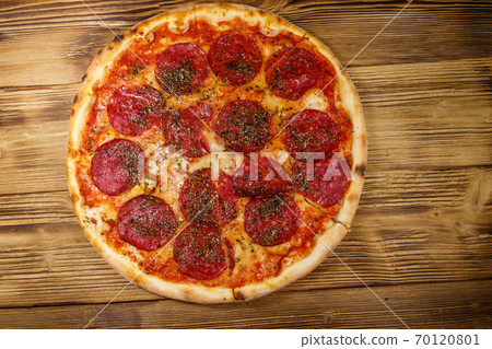 Delicious fresh pizza with sausage and cheese on a wooden table. Top view 70120801