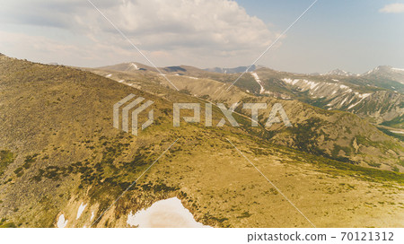 Green forest among the red mountains in the Magadan region. 70121312