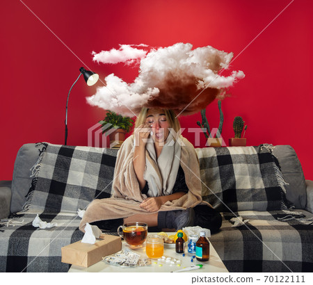 Ill young girl with fever and cold looks suffering at home Ill young girl with fever and cold looks suffering at home 70122111
