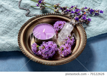 Pagan ritual. A purple candle, a crystal charm, and flowers, vervain and lavender 70122626