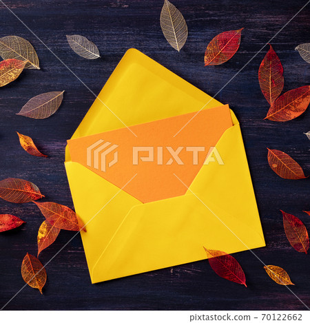 Autumn greeting card in an envelope, square mockup with copy space, with a flat lay of fall leaves, top shot 70122662