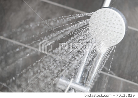 Water flows from rain shower in trickles into hotel bathroom Water flows from rain shower in trickles into hotel bathroom 70125829