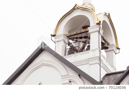 Beautiful white church with a cross and a dome. Big bells against the sky, catholic religion 70128036