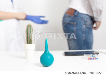 Doctor proctologist puts on medical gloves for a digital examination of the patient s rectum for diseases of the hemorrhoids and anal fissures, background 70128229