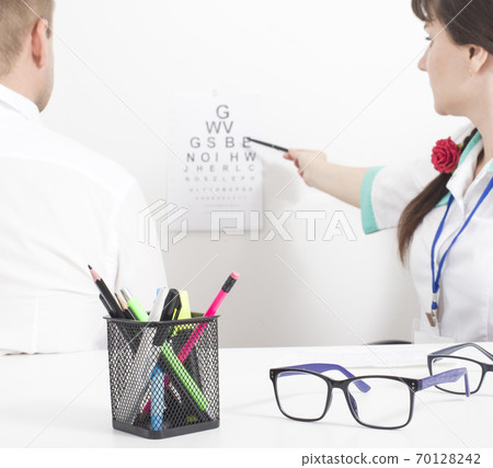 A patient is taken by an ophthalmologist who checks visual acuity. Ophthalmic diseases concept cataract and glaucoma, background 70128242