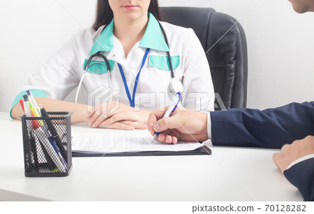 A man signs documents consenting to a sex change surgery. Sex change in a modern clinic, feminization 70128282