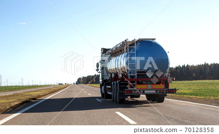 Tanker truck transporting bulk cargo on the highway, industry. Concept for the transportation of oil products and liquid food cargo, copy space for text 70128358