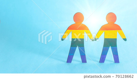 Two wooden male figures painted in multi-colored LGBT symbols. The concept of homosexuality and gay men, gay marriage, copy space 70128662