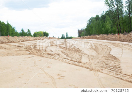 The construction of a wide road and sidewalk. Marking in the sand for a new footpath, background, copy space 70128725