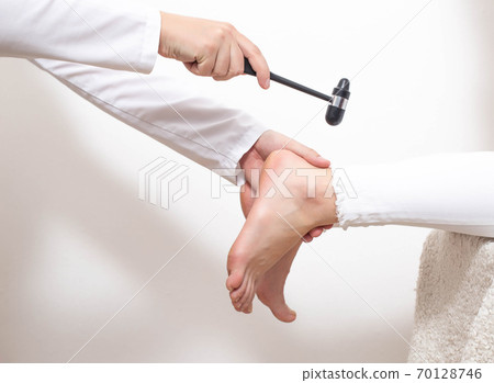 Checking the patient's Achilles reflex for the presence of a compressed nerve with injuries of the spine and spinal cord of an intervertebral hernia, copy space 70128746