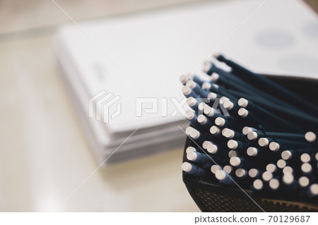 pens and pencils with an eraser on the end on the background of a stack of papers pens and pencils with an eraser on the end on the background of a stack of papers 70129687