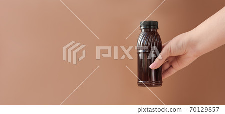 Hand holding cold brew coffee.  70129857