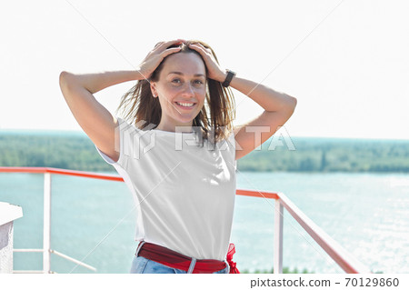 beautiful woman holding her hair blowing by the wind beautiful woman holding her hair blowing by the wind 70129860
