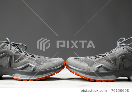 trekking sneakers with red sole, gray background with copy-space trekking sneakers with red sole, gray background with copy-space 70130608