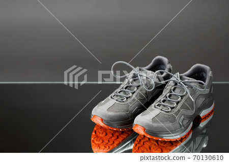 trekking sneakers with red sole, gray background with copy-space 70130610