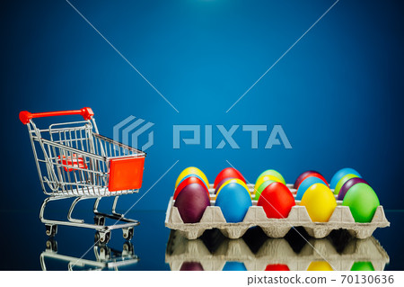 Easter festive multicolor eggs carton and shopping cart, blue background 70130636